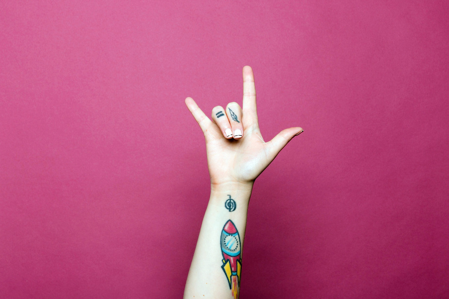 Female Hand with Tattoos with Love Sign Language 